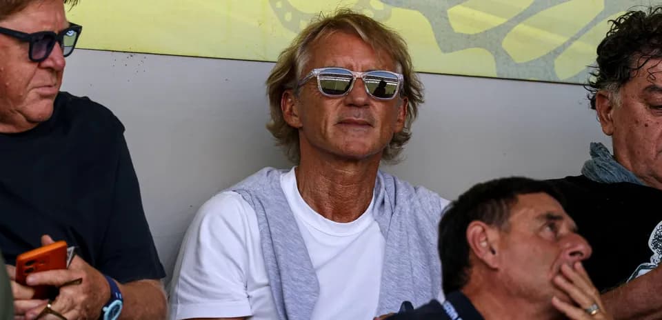Man wearing sunglasses sitting in crowd