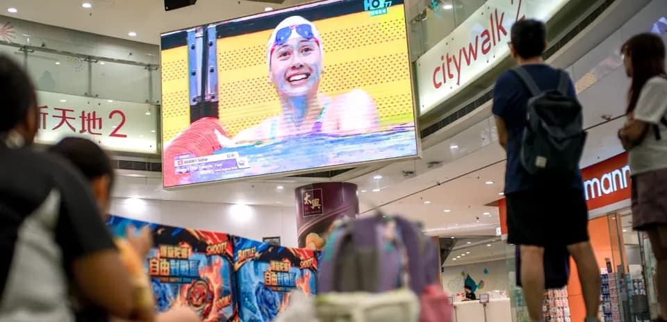 Swimmer celebrating on screen during competition broadcast