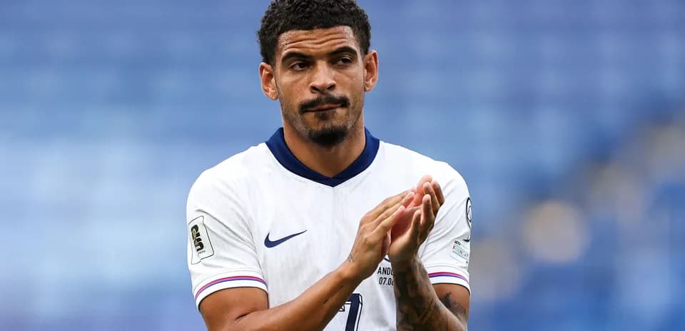 Futbolchi maydonda qo'llarini chalqanayotgan