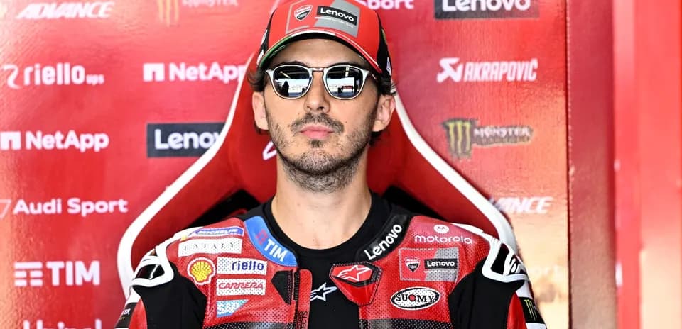 Motorsport athlete sitting in racing gear with sunglasses