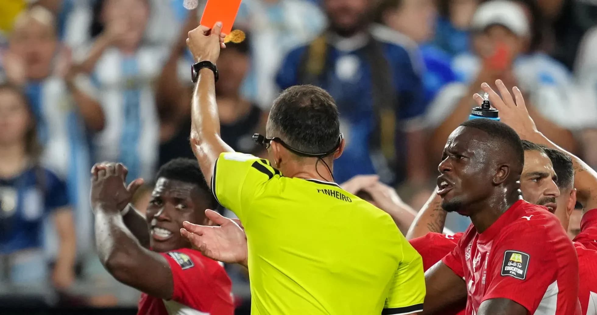 Referee showing red card to player during match