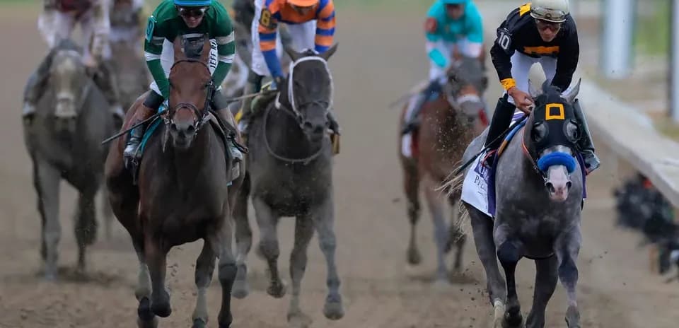 Horses racing on dirt track during competition