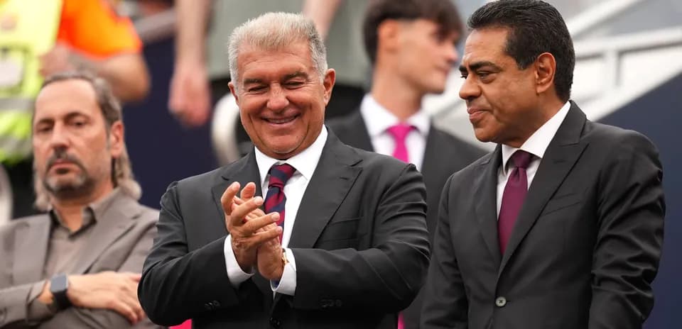 Three men in suits at a sporting event