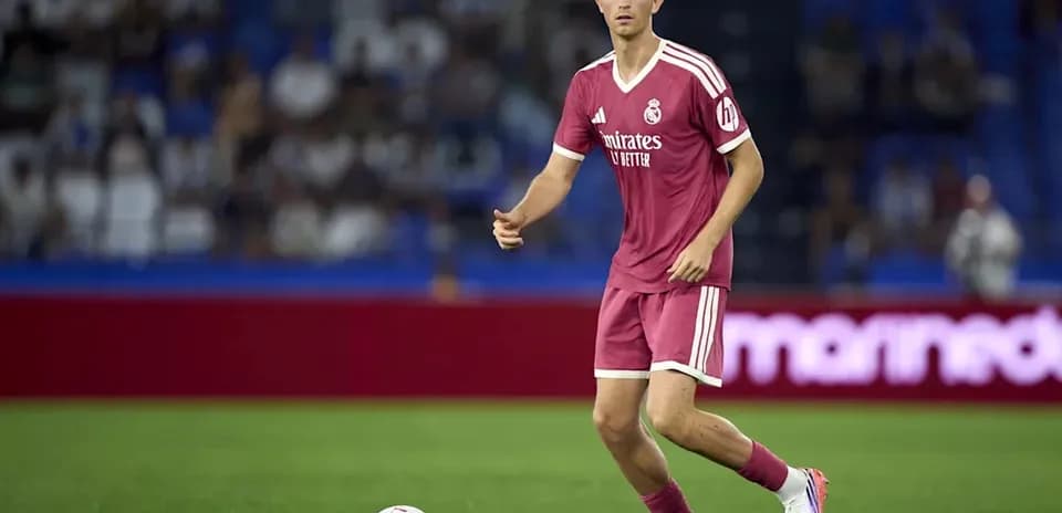 Futbolchi Real Madrid formasida to'pni ushlayotgan