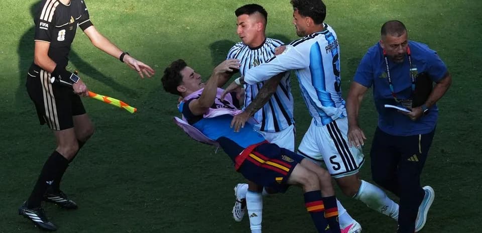 Players clashing during a match with referee observing