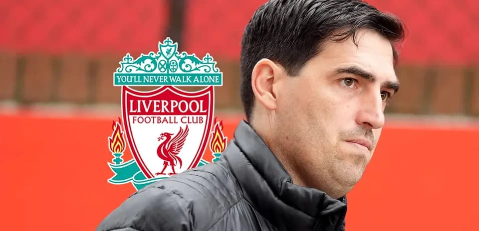 Man standing in front of Liverpool FC logo