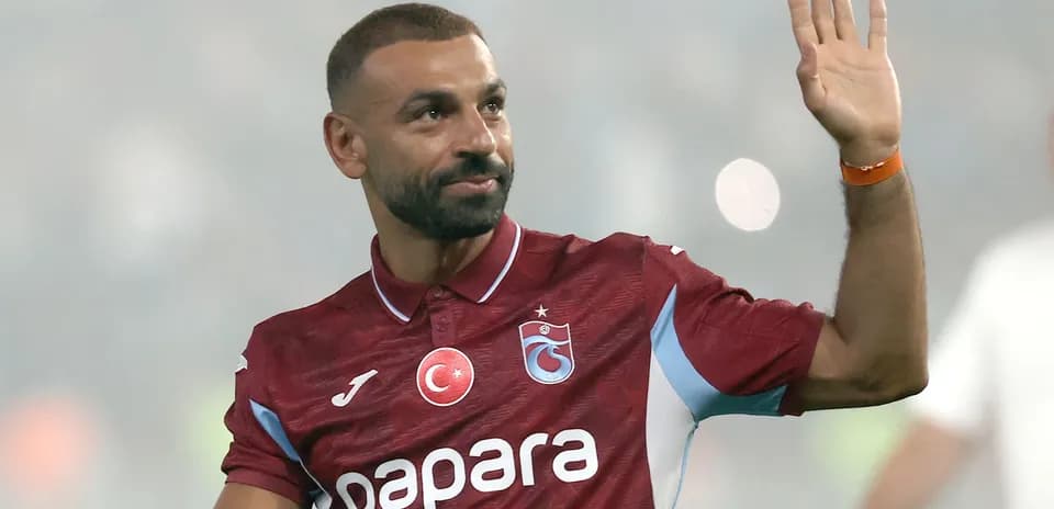 Futbolchi stadionda muxlislarga qo'l silkmoqda
