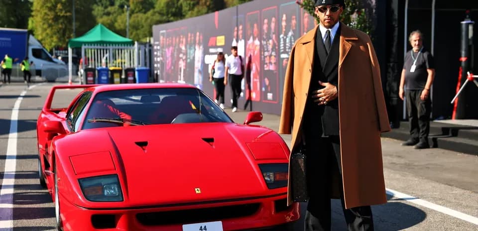 Shirted man standing next to red Ferrari F40