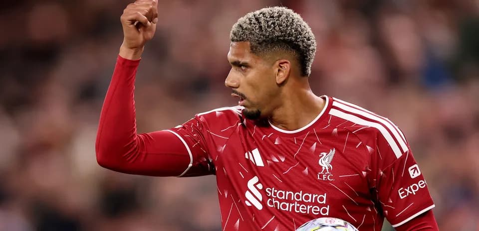 Futbolchi Liverpool formasida ko'tarilgan qo'l bilan