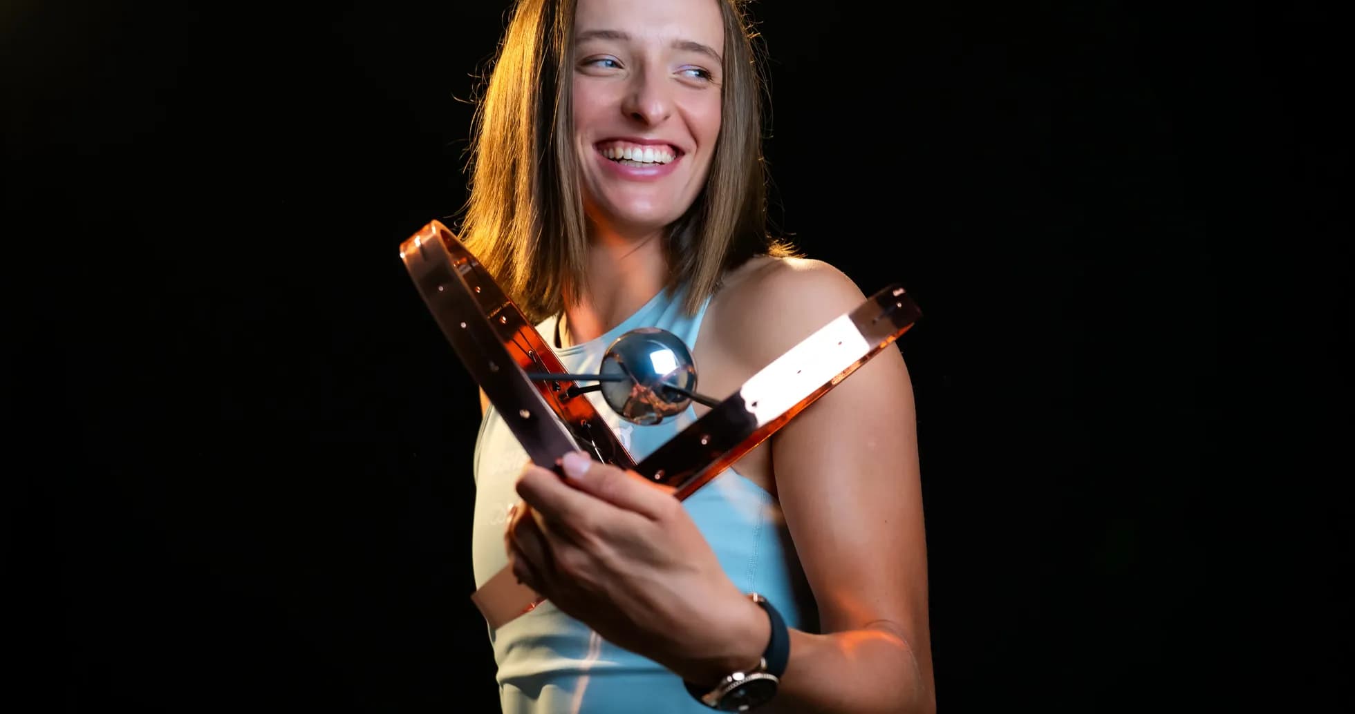 Athlete holding a trophy and smiling brightly