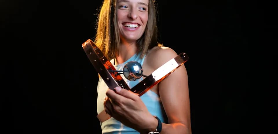 Athlete holding a trophy and smiling brightly