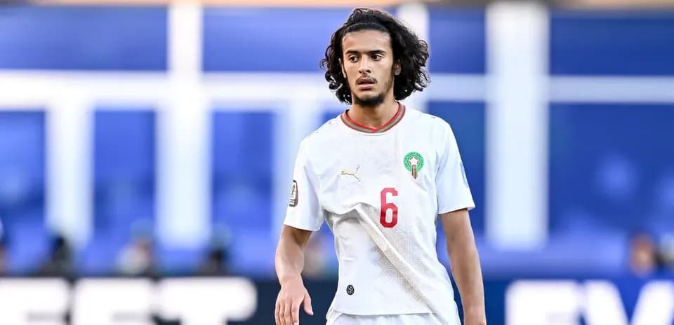 Futbolchi maydonda harakatda, oq forma kiygan