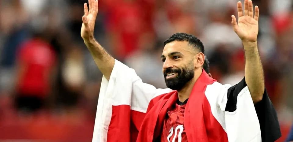 Futbolchi qo'lini ko'tarib muxlislarga salom berayapti
