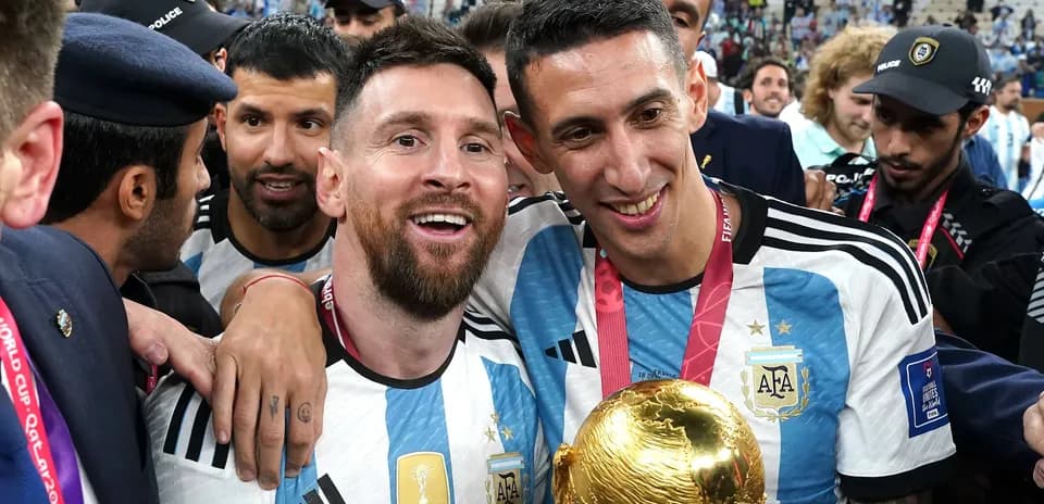 Messi and Di Maria celebrating with World Cup trophy