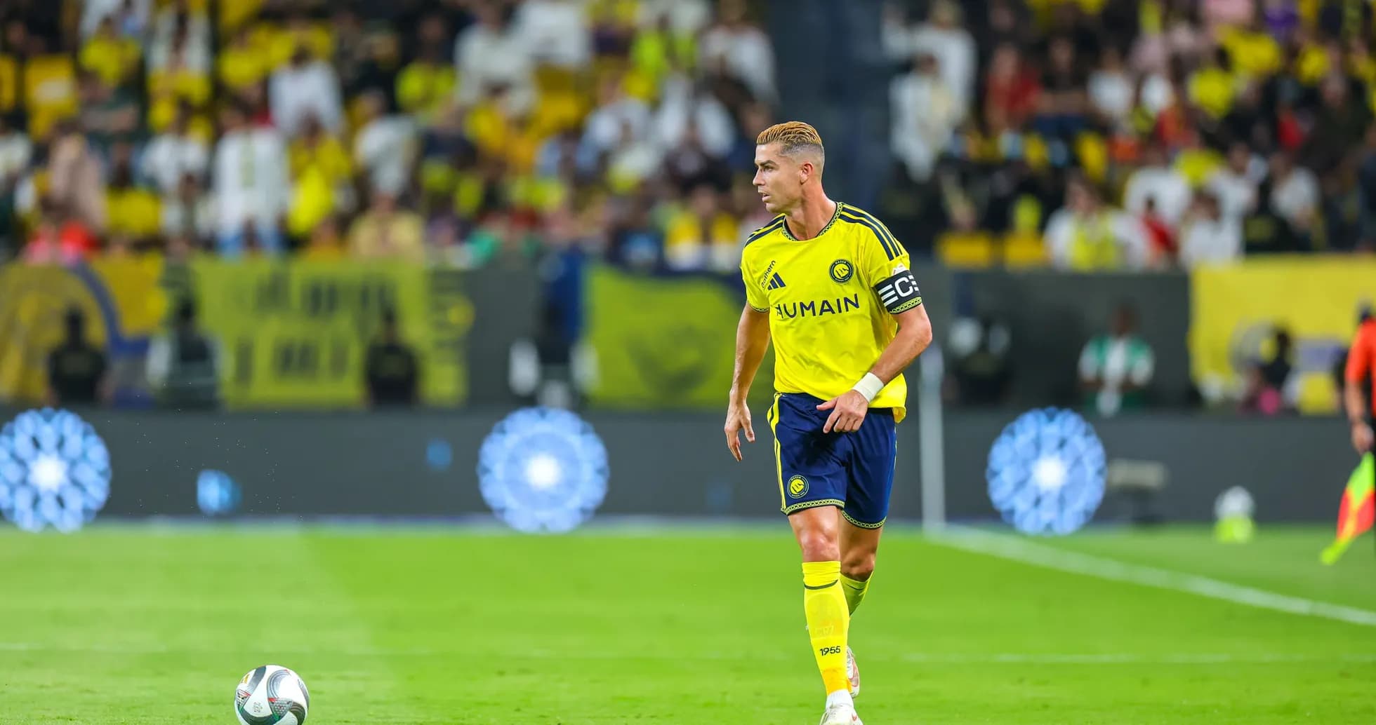 Futbolchi maydonida to'p bilan harakatlanmoqda