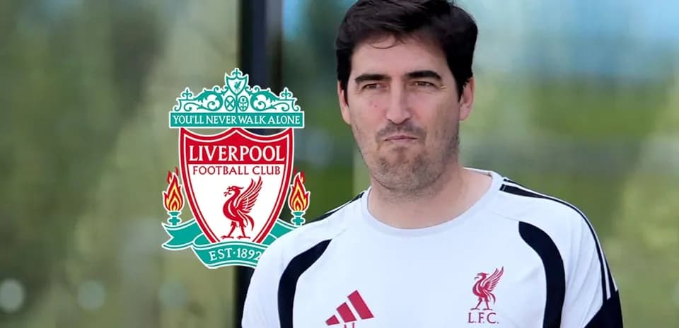 Person in Liverpool FC training kit near club logo