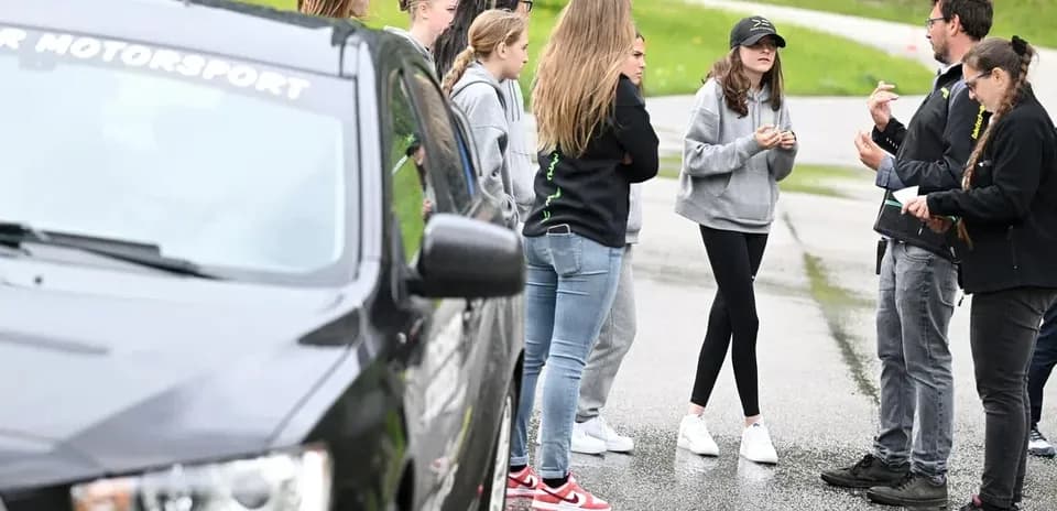 Group discussing near car during motorsport event