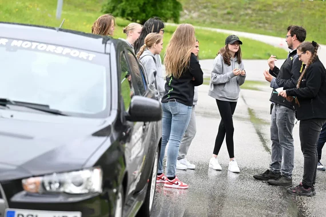 Group discussing near car during motorsport event