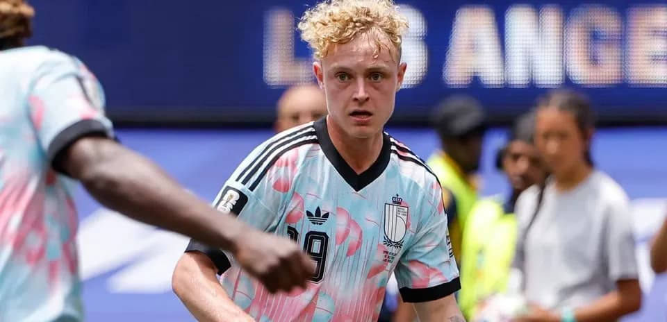 Futbolchi maydonda harakatda, raqibga qarab turibdi