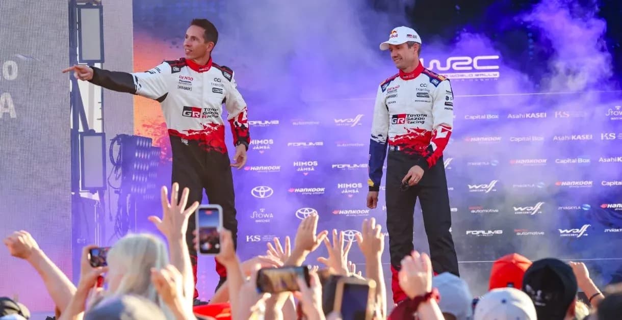 Rally drivers celebrating on stage with fans