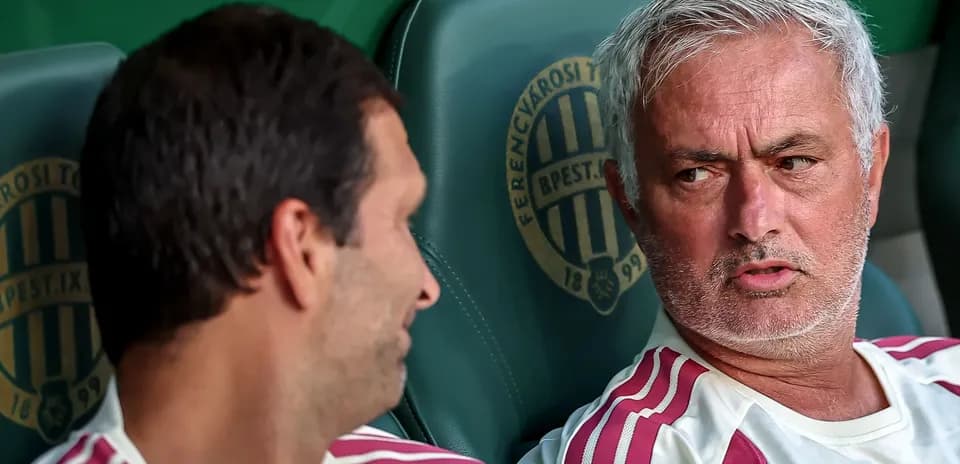 Two coaches conversing on the bench during match