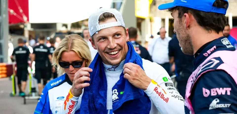 Driver interacting with team members in paddock area