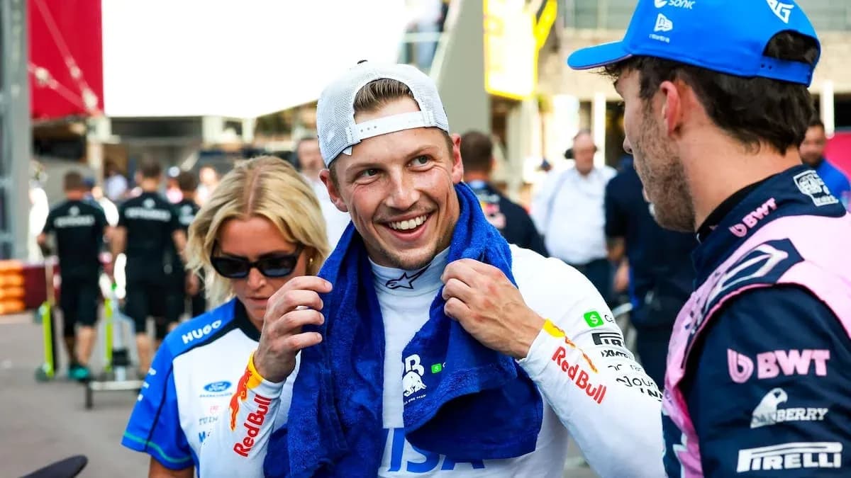 Driver interacting with team members in paddock area
