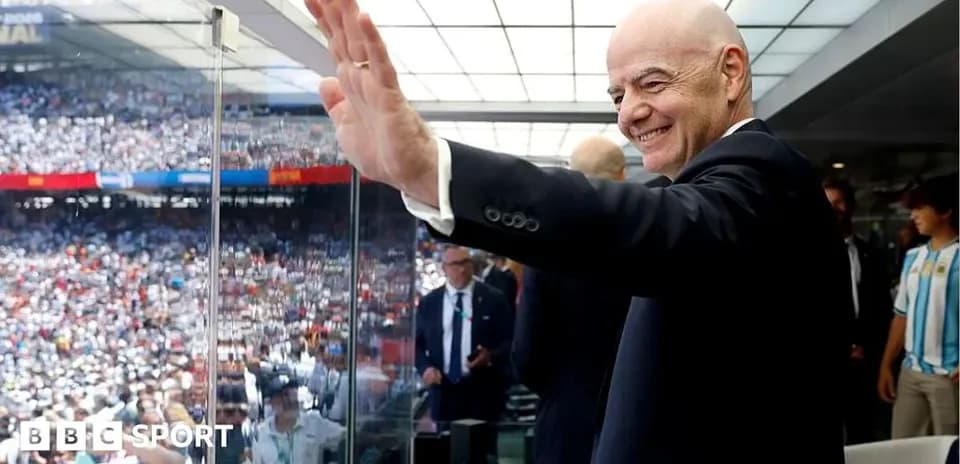 Person waving from VIP box during football match