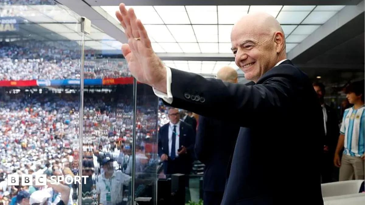 Person waving from VIP box during football match