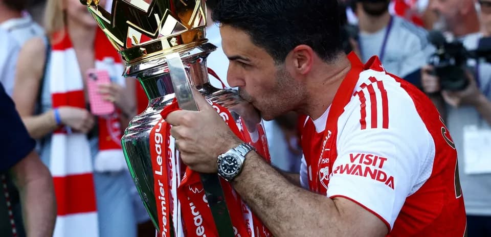 Mikel Arteta kissing Premier League trophy in celebration