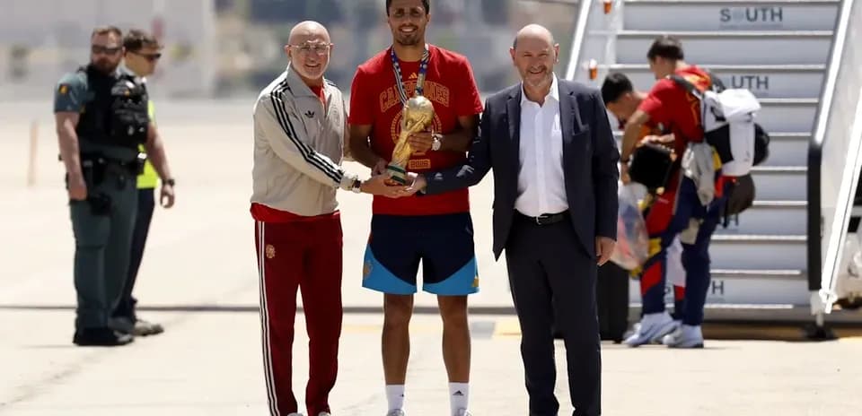Football player receiving trophy at airport arrival
