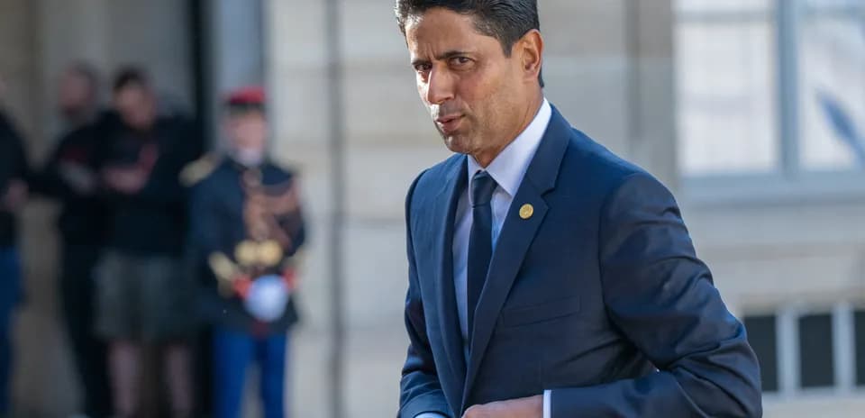 Man in suit walking outside near soldiers