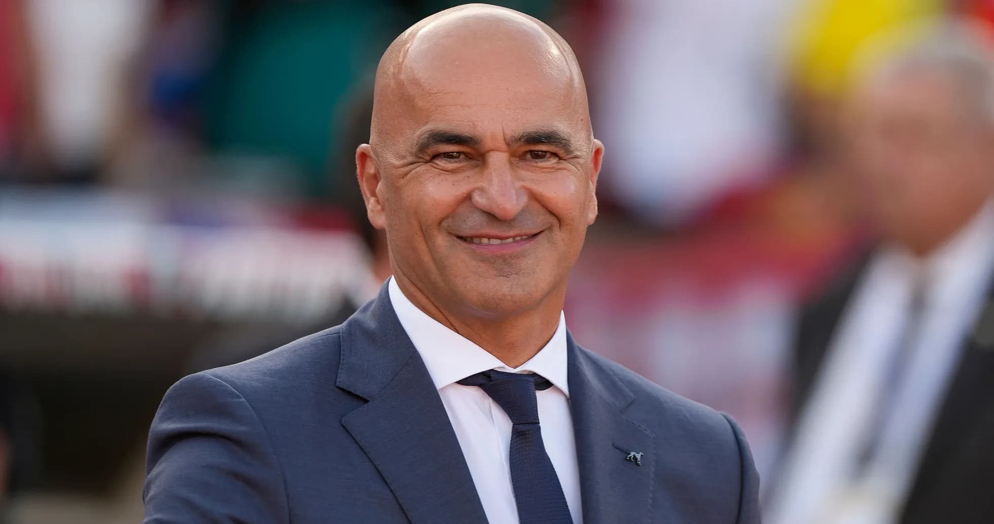 Bald man in a suit smiling at event