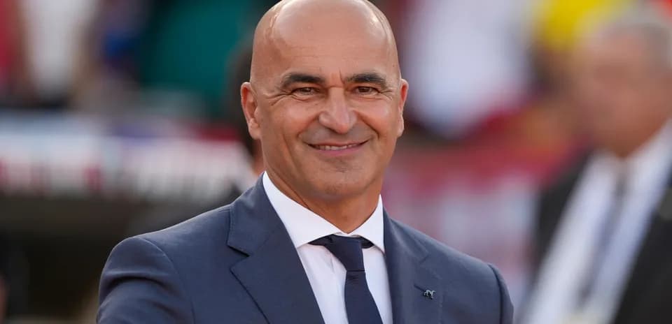 Bald man in a suit smiling at event