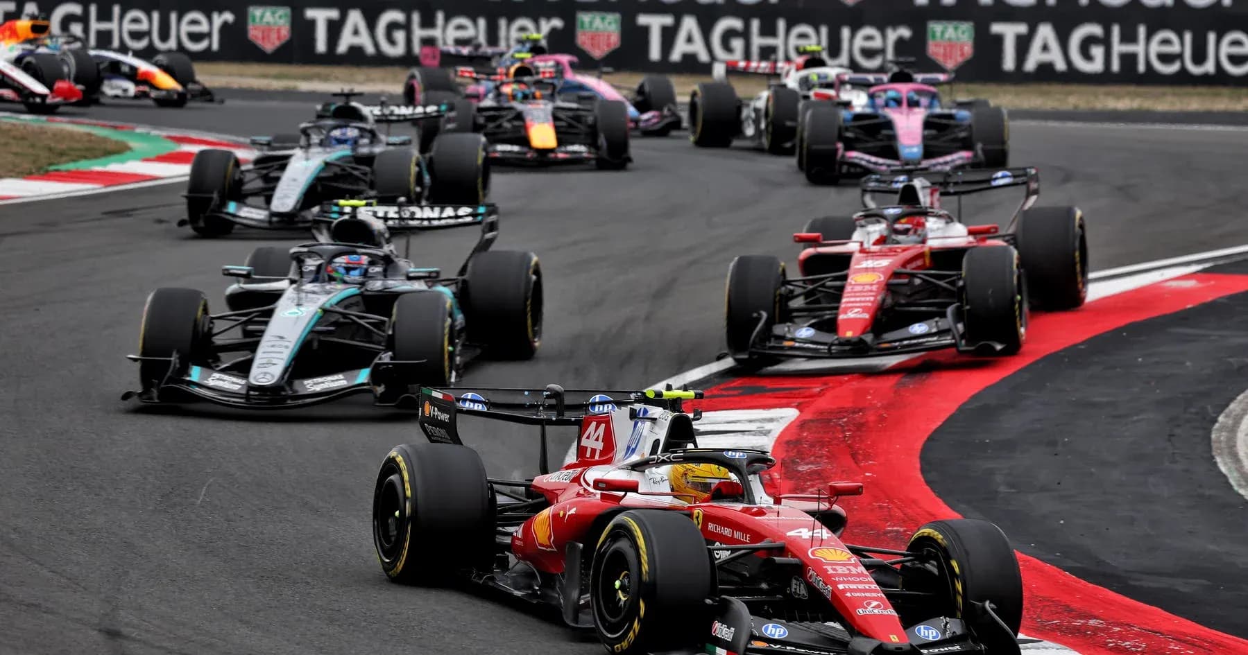 Formula 1 cars racing at a track corner