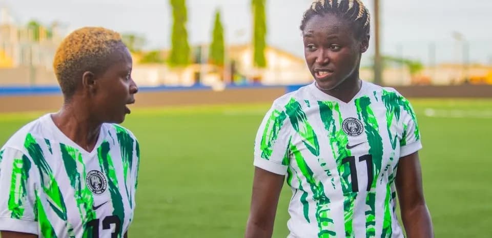 Ikki futbolchi mashg'ulotda bir-biriga qaramoqda