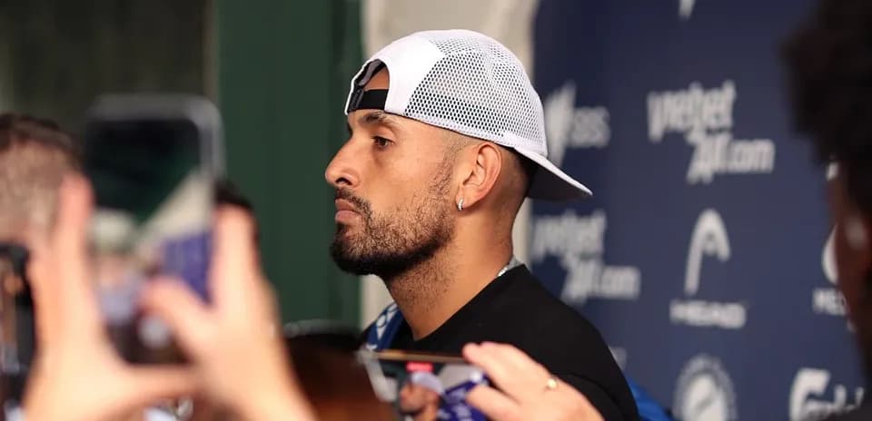 Athlete speaking to media with microphones nearby