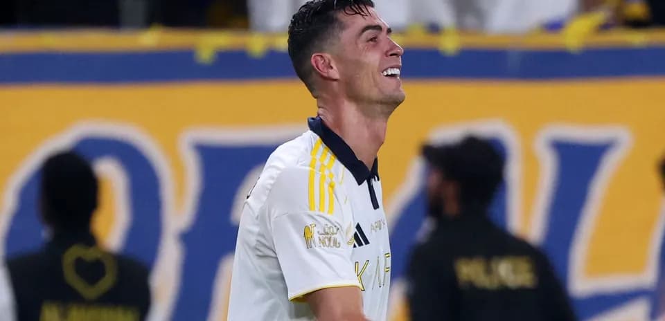 Futbolchi maydonda raqibga qarshi kurashmoqda