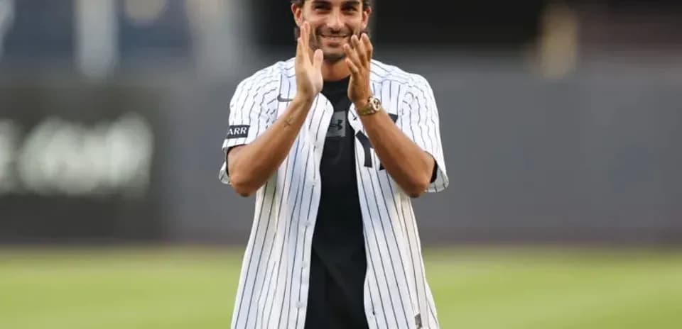 Man applauding while wearing a baseball jersey