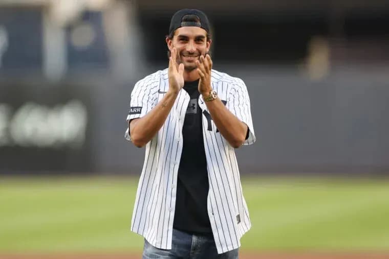 Man applauding while wearing a baseball jersey