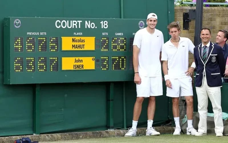 Players and officials by scoreboard at Wimbledon