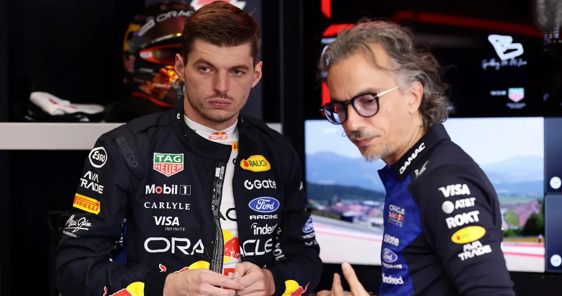 Max Verstappen discussing with team engineer in garage