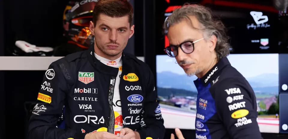 Max Verstappen discussing with team engineer in garage