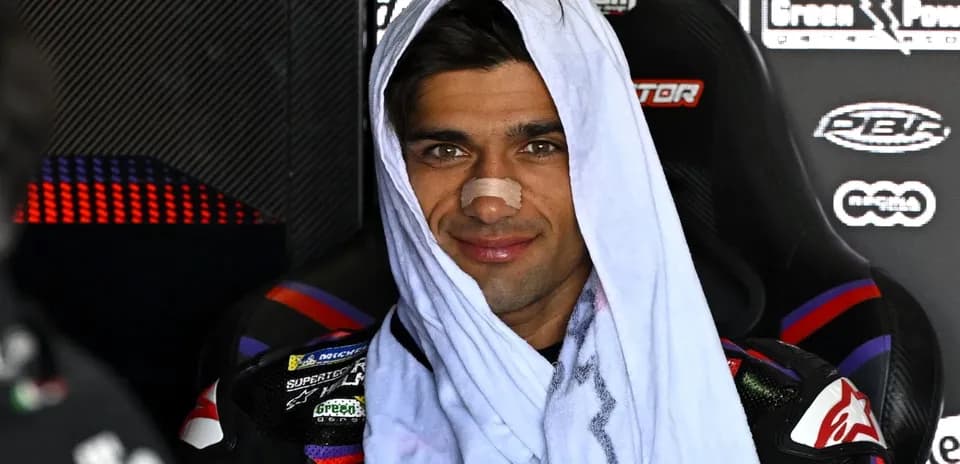 Motorcycle racer with towel and bandage on nose