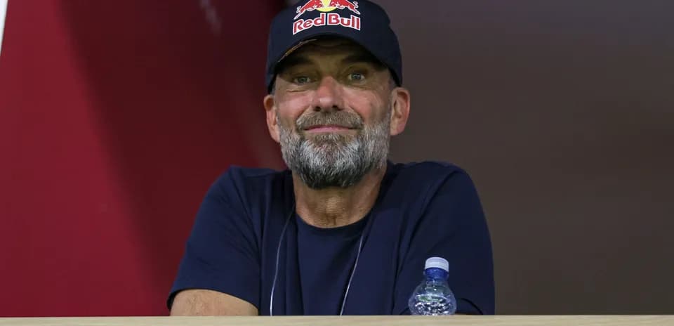 Man in Red Bull cap observing from a balcony