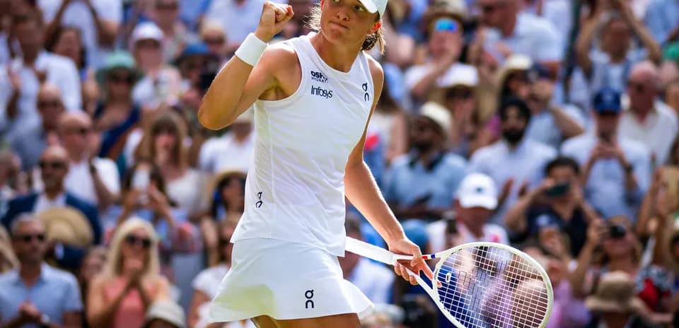 Tennis player celebrating in front of cheering crowd