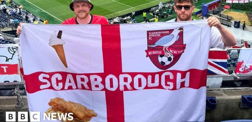 Fans holding Scarborough Athletic FC flag in stadium