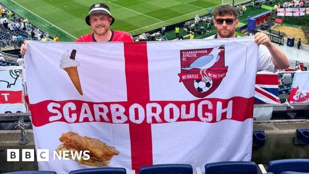 Fans holding Scarborough Athletic FC flag in stadium