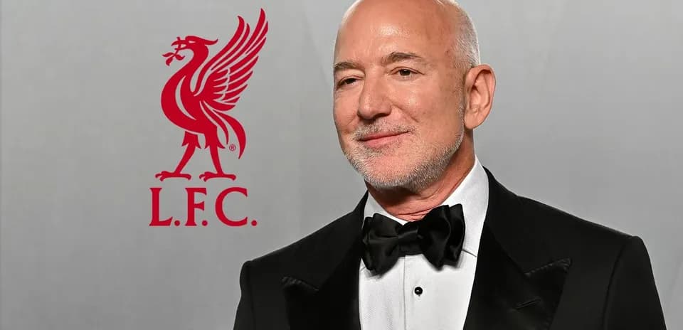Man in tuxedo with Liverpool FC logo backdrop