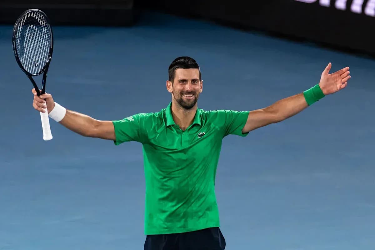 Tennis player celebrating with arms raised after match
